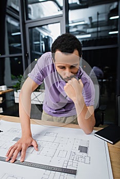 pensive african american architect holding pencil