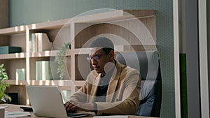 Pensive African American man ethnic businessman millennial employer ceo manager at office with computer laptop paperwork