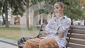 Pensive African Woman Thinking while Sitting Outdoor on Bench