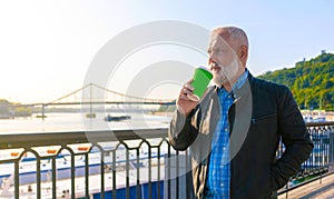 Pensive aged man drinking coffee outdoors stock photo