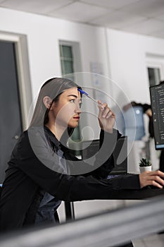 Pensive asian web developer working on html code development