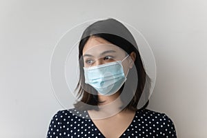 Pensive Asian woman in medical face mask look in distance