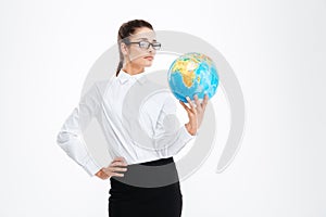 Pensive attractive young business woman holding earth globe