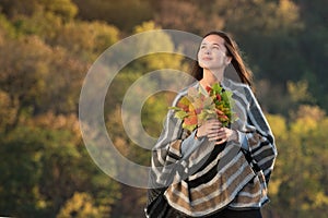 Pensive beautiful girl with autumn leaves in her hands. Dream thoughts about life