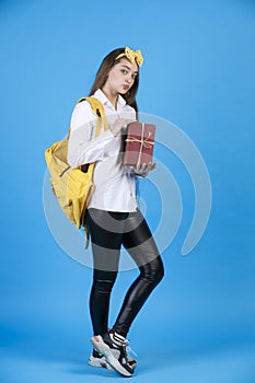 Pensive, beautiful girl with funny yellow headband pouting lips, while posing at camera.