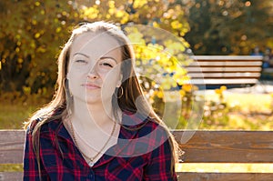 Pensive beautiful girl with long hair looks directly at camera i