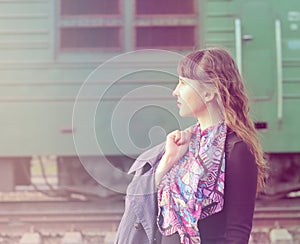 Pensive beautiful girl at the train station