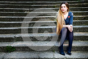 Pensive beautiful woman on stone steps