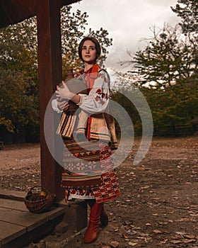 Pensive beautiful young woman dressed traditional ukrainian embroidered clothes looking away. Vintage outfit