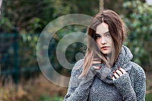 Pensive beautiful young woman in woolen sweater