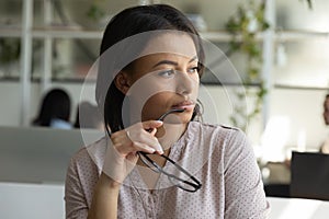 Pensive biracial female worker look in distance thinking