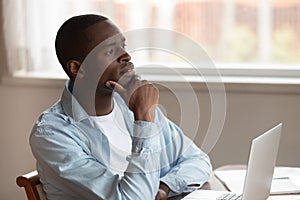 Pensive biracial man distracted from laptop work thinking