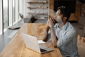 Pensive biracial man work on laptop thinking