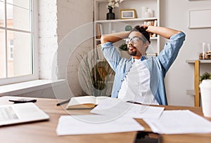 Pensive black businessman looking out of window in office