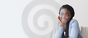 Pensive black girl resting her head on hand, relaxing at home