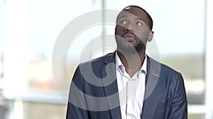 Pensive black man thinking and looks up.