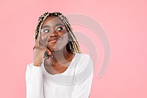 Pensive black woman thinking isolated on pink background