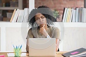 Pensive black woman work at laptop thinking making decision