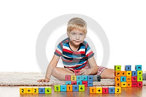 Pensive boy with blocks on the floor