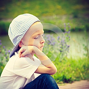 Pensive boy child thinking and daydreaming.