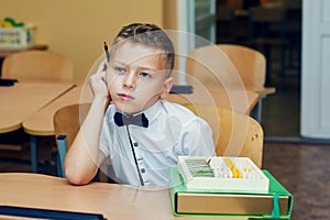 Pensive boy in class in elementary school . The concept of primary education