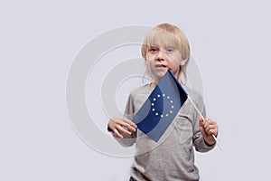 Pensive boy holding flag of European Union. Traveling with children in Europe