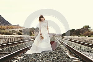 Pensive bride with a red suitcase