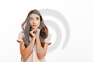 Pensive brunette woman in t-shirt reclines on her arms