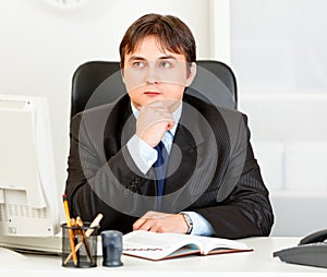 Pensive business man planning timetable in diary