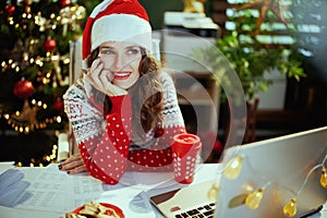 pensive business woman in green office with Christmas tree