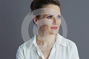 pensive business woman looking at copy space isolated on gray