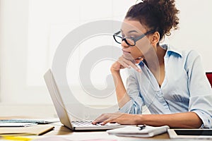 Pensive business woman working on laptop at office