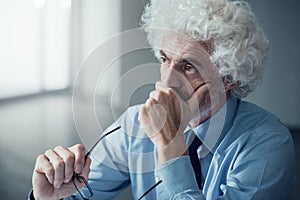 Pensive businessman with hand on chin