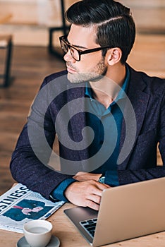 Pensive businessman with laptop in cafe