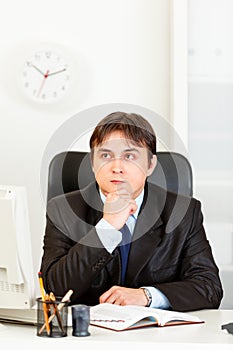 Pensive businessman planning timetable in diary