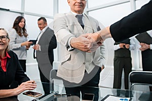 Pensive businessman shaking hands with his colleague.