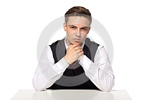 Pensive businessman sitting at the table isolated on white background