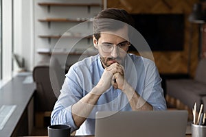 Pensive businessman work on laptop making decision