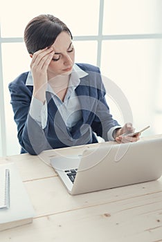 Pensive businesswoman reading sms