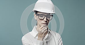 Pensive businesswoman with safety helmet