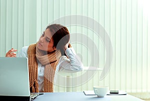 Pensive businesswoman sitting on her workplace and looking away