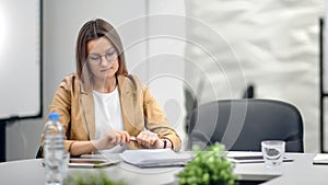 Pensive businesswoman thinking about work sitting at desk in office