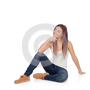 Pensive casual young woman sitting on the floor