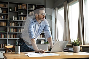 Pensive Caucasian man distracted from computer thinking