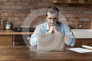 Pensive Caucasian man work on computer thinking