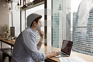 Pensive Caucasian man work on laptop thinking