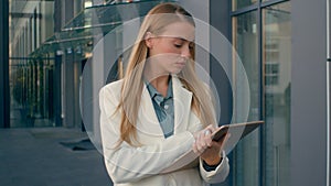 Pensive Caucasian woman student manager walking with tablet female thinking about problem ponder. Serious girl worker photo