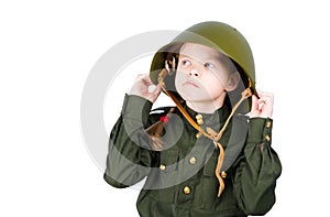 Pensive child in military uniform and helmet, looking away
