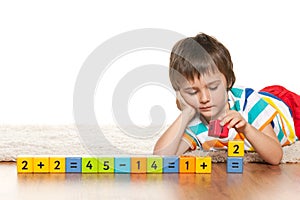 Pensive clever boy with blocks