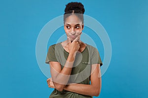 Pensive confused young african american woman girl in casual t-shirt posing isolated on blue background in studio